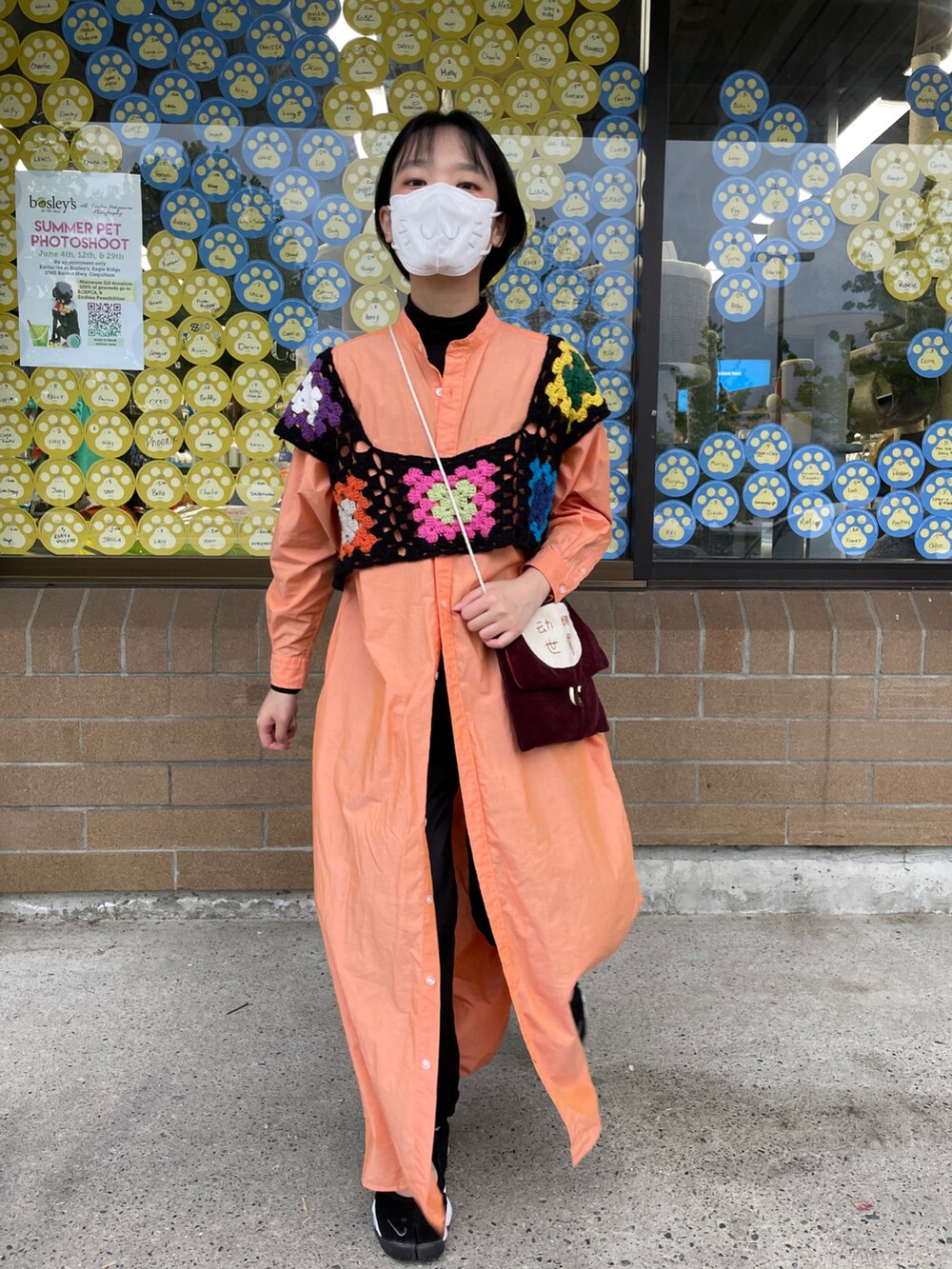 オレンジ系のワンピース、その他のニット/セーター、ブラック系のスニーカーを着用したレディースの夏コーディネートの2枚目の写真