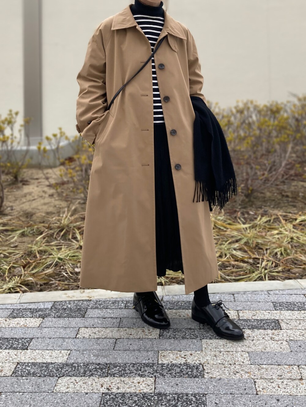 ベージュ系のジャケット/アウター、ブラック系のTシャツ/カットソー、ブラック系のドレスシューズを着用したレディースの春コーディネートの2枚目の写真