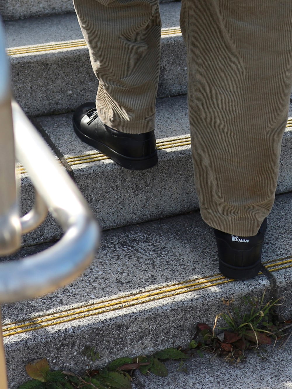 ブラック系のスニーカー、ベージュ系のその他アウター、ブラック系のスウェットを着用したメンズの冬コーディネートの3枚目の写真