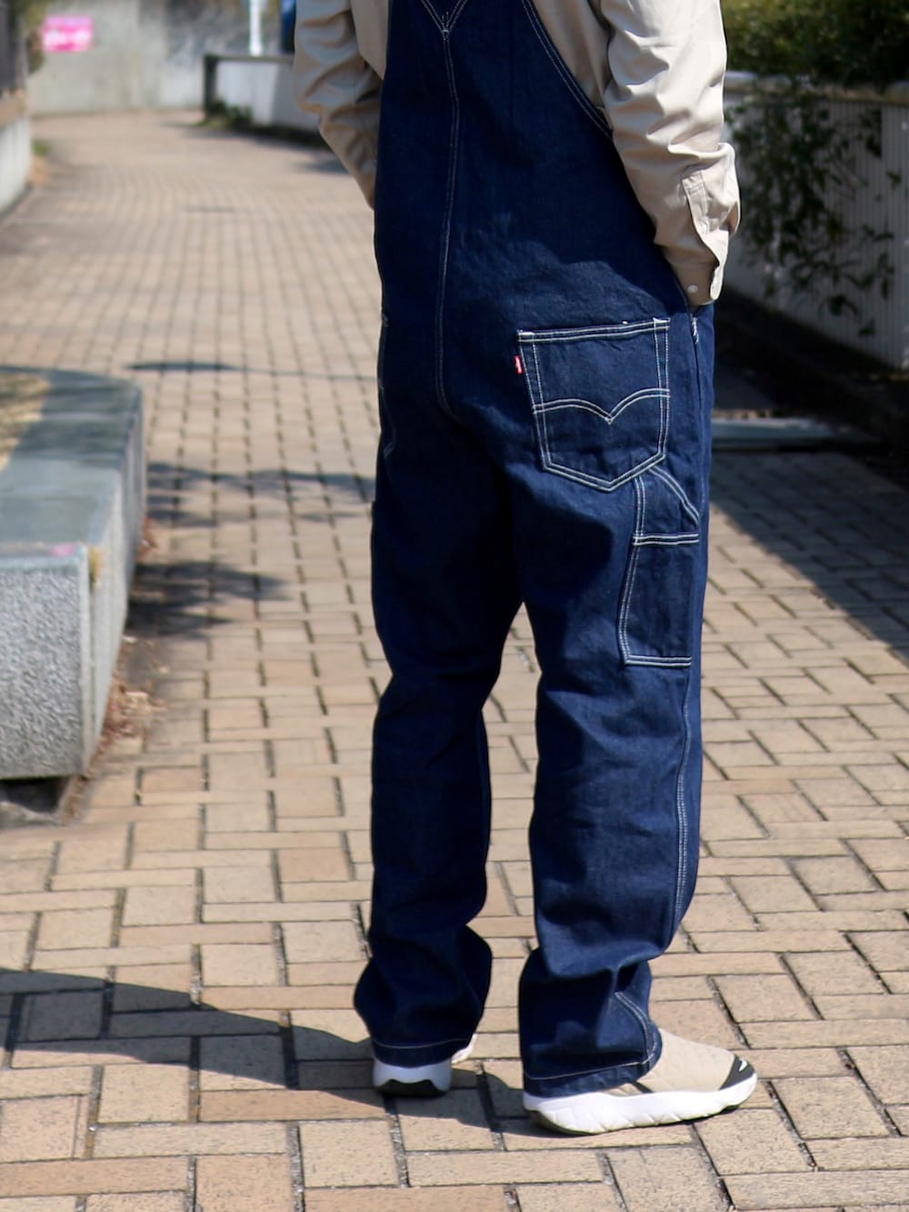 ブルー系のサロペット/オーバーオール、ブルー系のジャケット/アウター、ベージュ系のシャツ/ブラウスを着用したメンズの春コーディネートの3枚目の写真