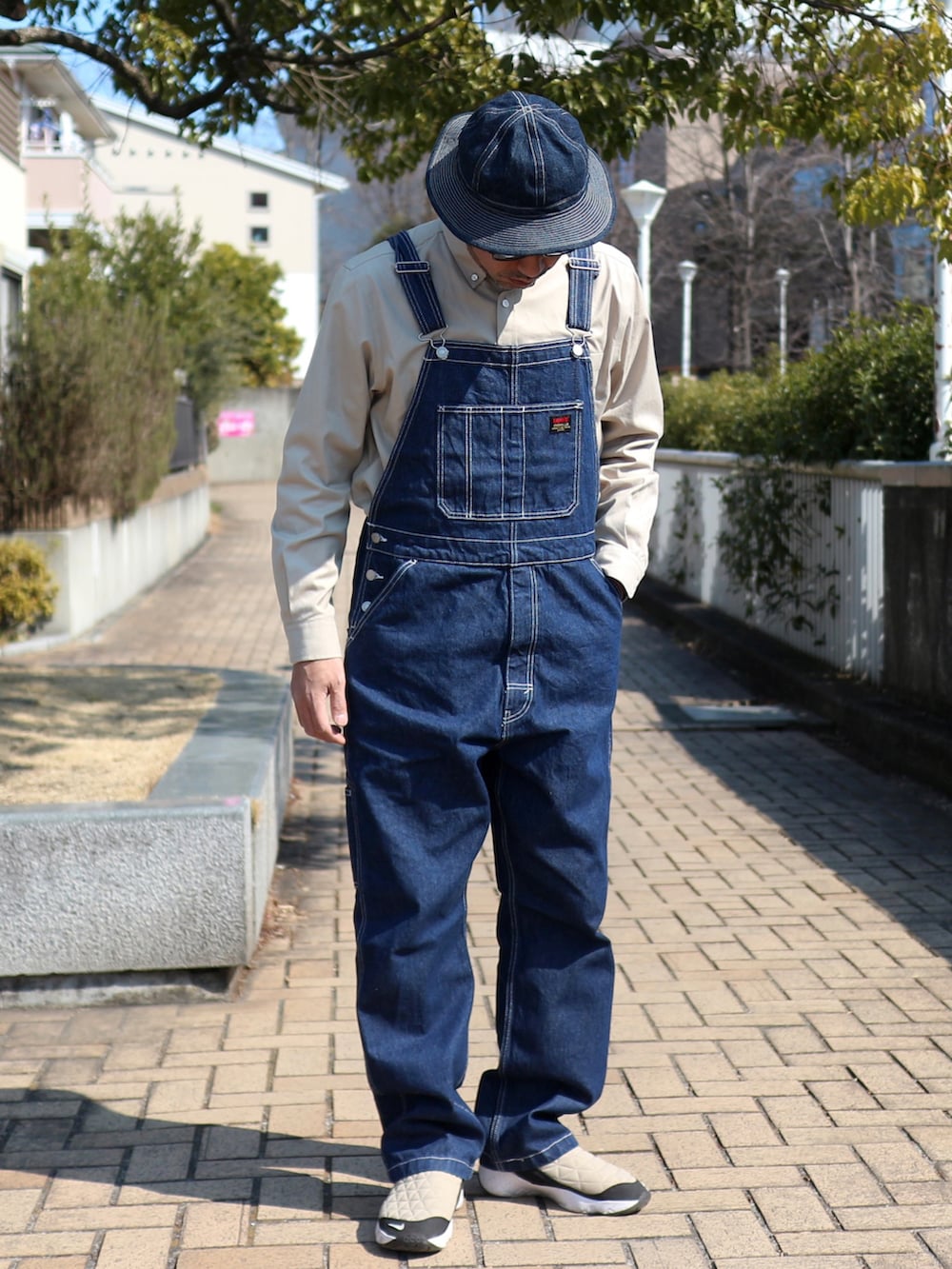 ブルー系のサロペット/オーバーオール、ブルー系のジャケット/アウター、ベージュ系のシャツ/ブラウスを着用したメンズの春コーディネートの4枚目の写真