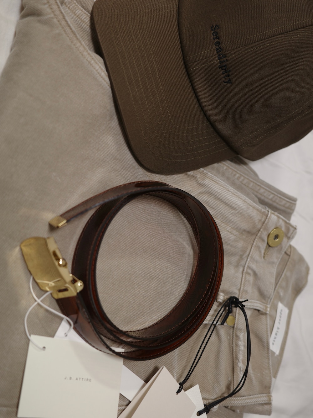 ベージュ系のデニムパンツ、ベージュ系のスニーカー、ブラウン系のボストンバッグを着用したレディースの秋コーディネートの2枚目の写真