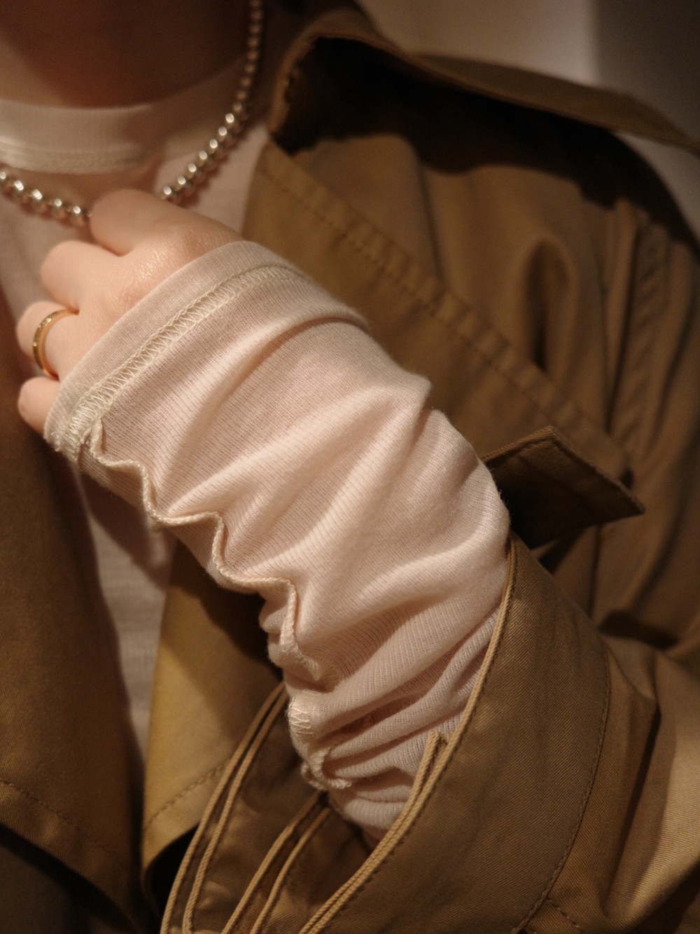 ブラック系のバッグ、ベージュ系のトレンチコート、ベージュ系のTシャツ/カットソーを着用したレディースの春コーディネートの3枚目の写真