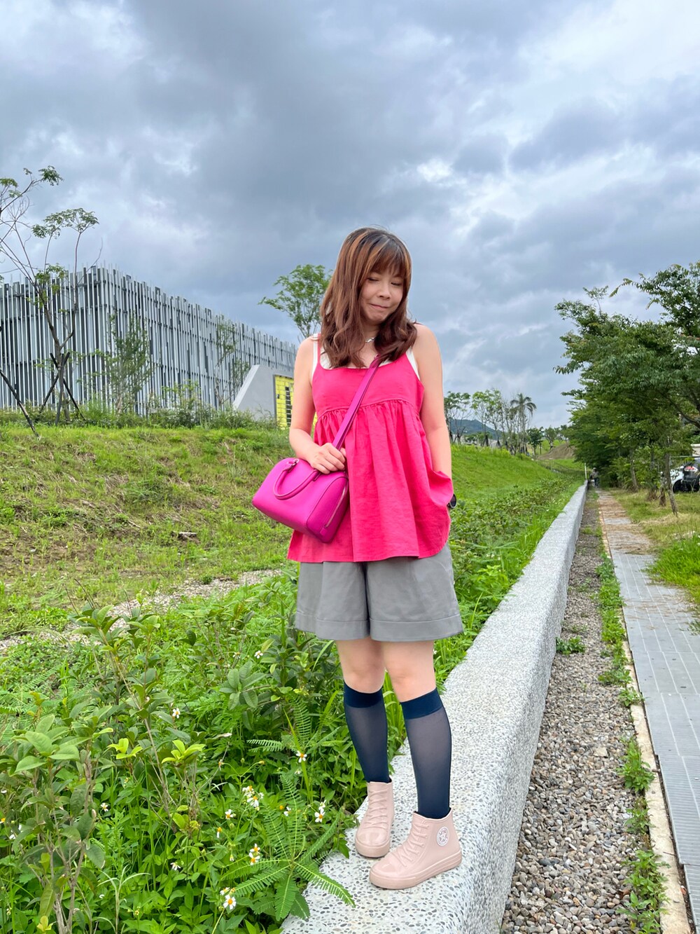 ピンク系のキャミソール、グレー系のスラックス、ホワイト系のタンクトップを着用したレディースの夏コーディネートの2枚目の写真