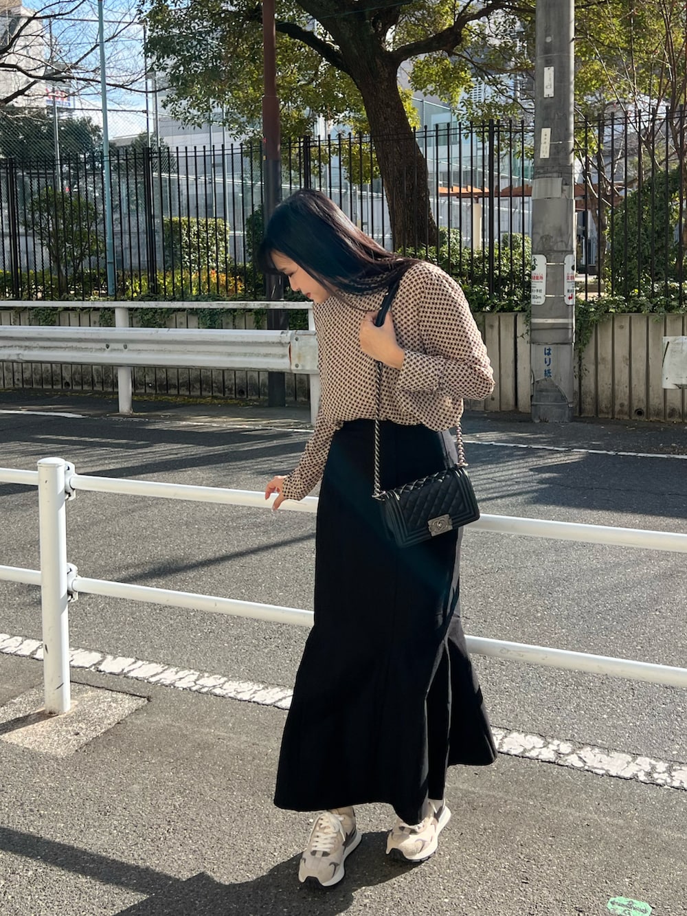 ブラック系のスカート、ベージュ系のスニーカー、ベージュ系のトップスを着用したレディースの冬コーディネートの2枚目の写真