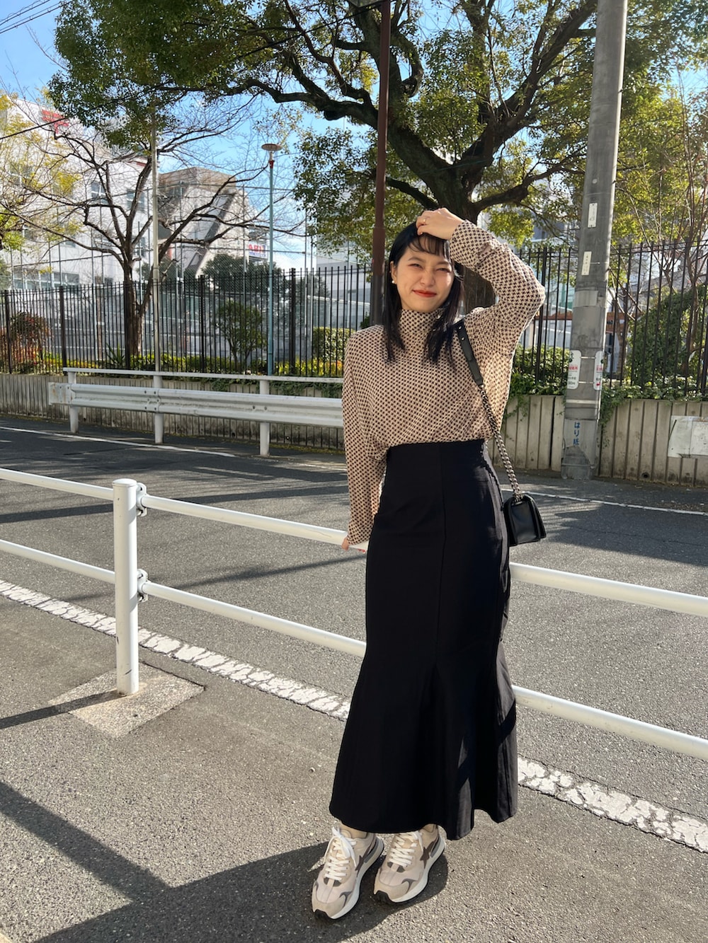 ブラック系のスカート、ベージュ系のスニーカー、ベージュ系のトップスを着用したレディースの冬コーディネートの3枚目の写真