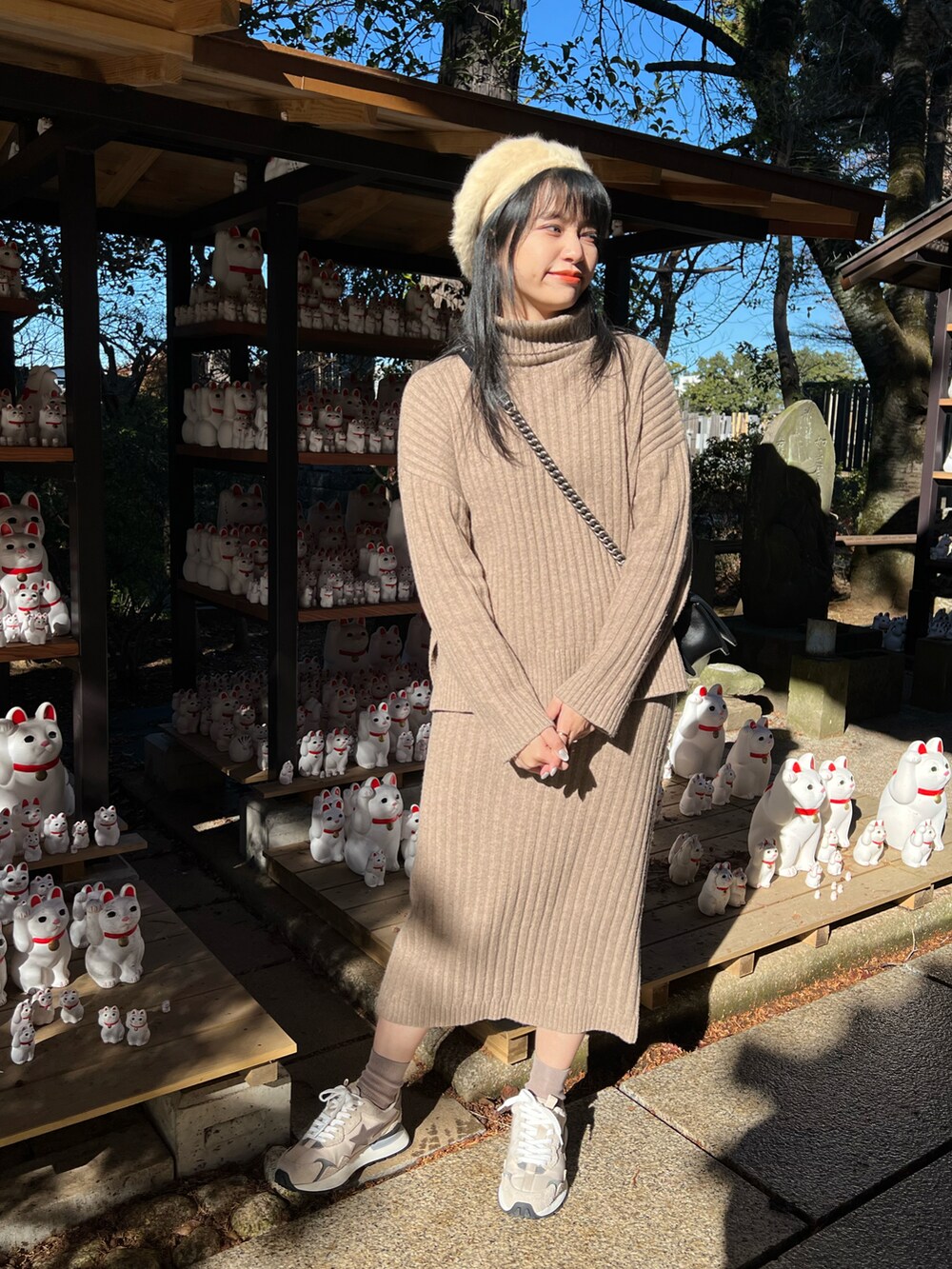 ブラック系のショルダーバッグ、ベージュ系のハンチング/ベレー帽を着用したレディースの冬コーディネートの2枚目の写真