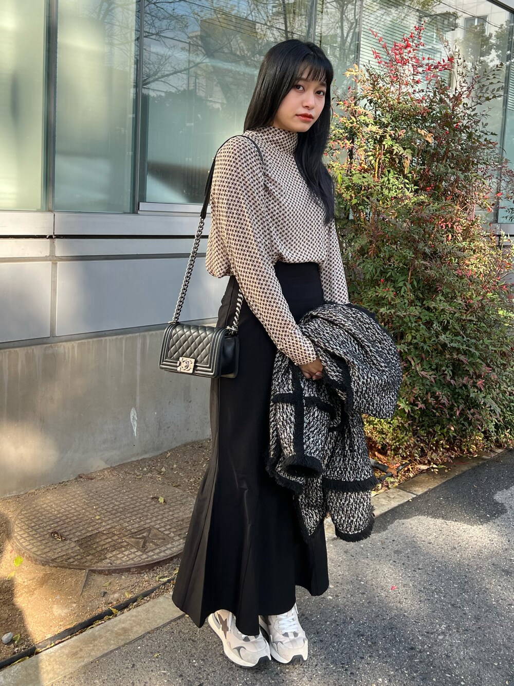 ブラック系のスカート、ベージュ系のスニーカー、ベージュ系のトップスを着用したレディースの冬コーディネートの4枚目の写真