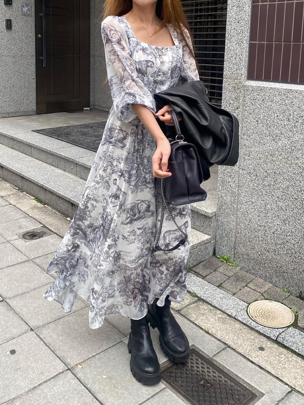 ブラック系のジャケット/アウター、ブラック系のワンピース、ブラック系のブーツを着用したレディースの春コーディネートの2枚目の写真