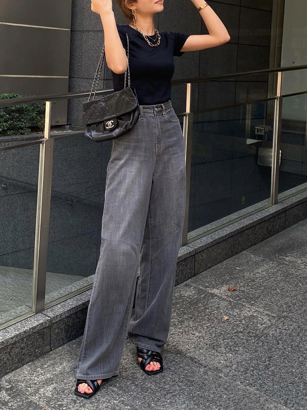 ブラック系のTシャツ/カットソー、ブラック系のデニムパンツ、ブラック系のショルダーバッグを着用したレディースの夏コーディネートの3枚目の写真