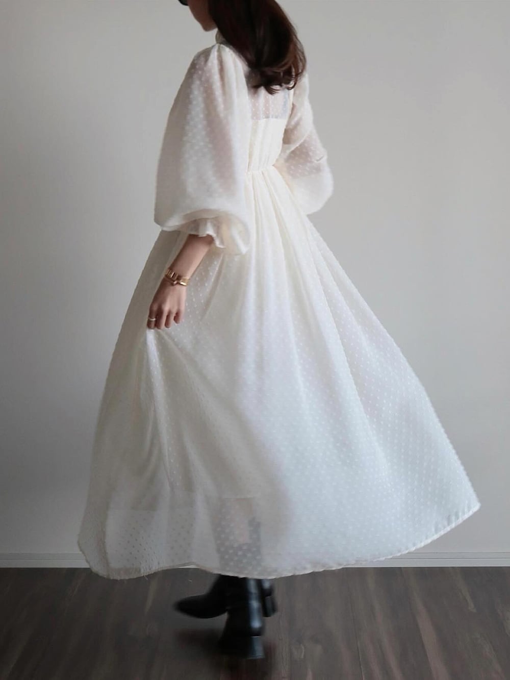 ホワイト系のワンピース、ベージュ系のキャップを着用したレディースの春コーディネートの4枚目の写真