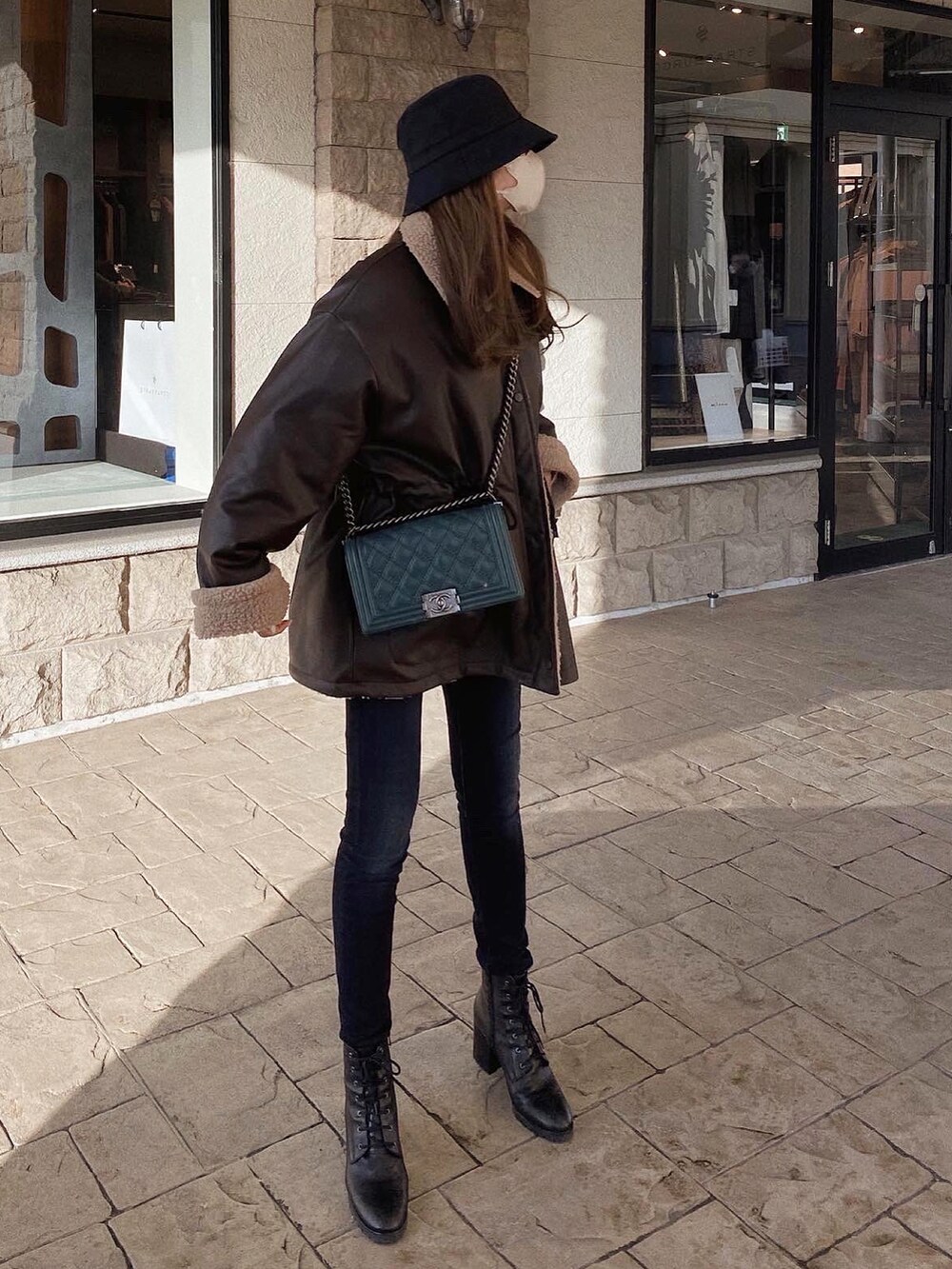 ブラウン系のジャケット/アウター、ブラック系のブーツ、グリーン系のショルダーバッグを着用したレディースの冬コーディネートの2枚目の写真