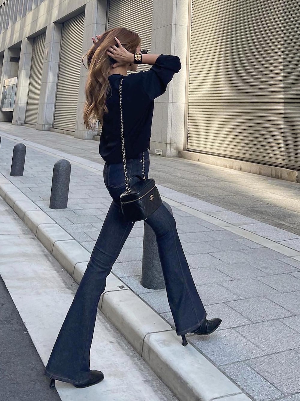 ブルー系のデニムパンツ、ブラック系のショルダーバッグ、ブラック系のシャツ/ブラウスを着用したレディースの秋コーディネートの2枚目の写真