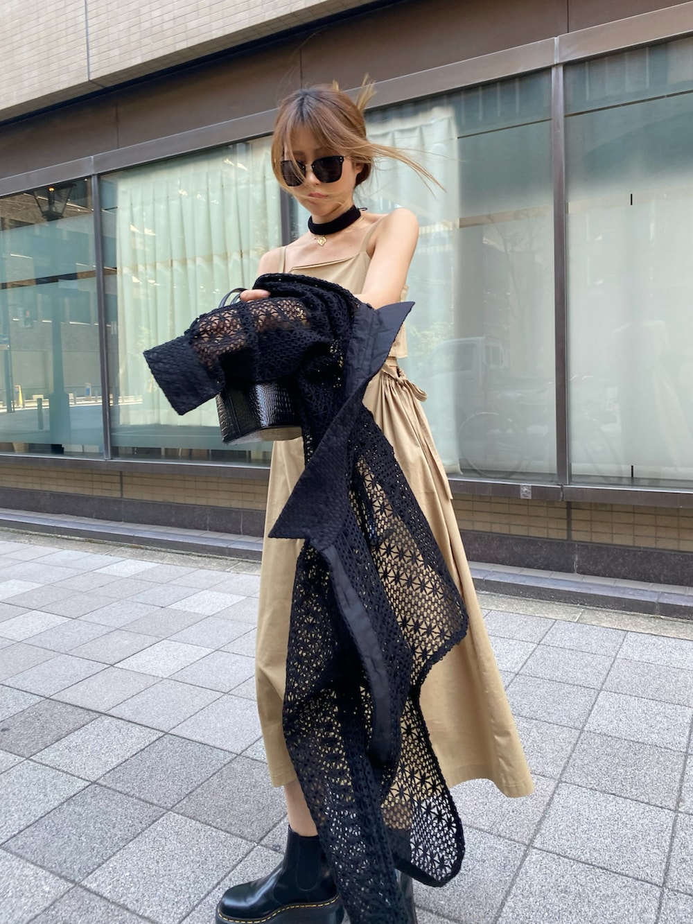 ブラック系のブーツ、ベージュ系のワンピース、ブラック系のシャツ/ブラウスを着用したレディースの夏コーディネートの3枚目の写真