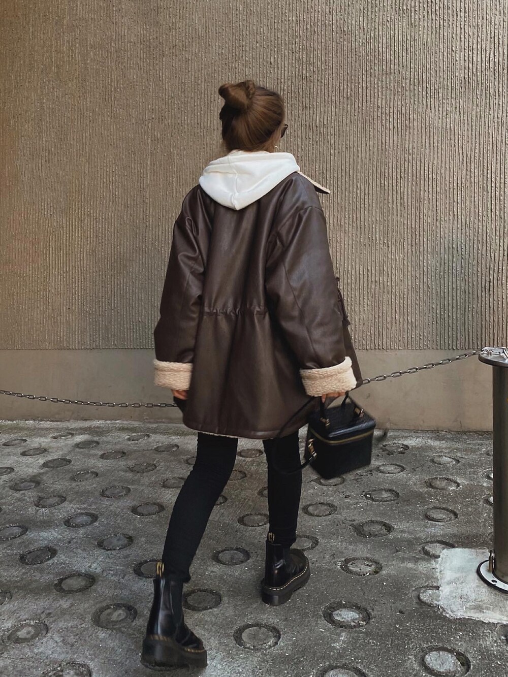 ブラウン系のジャケット/アウター、ホワイト系のパーカー、ブラック系のデニムパンツを着用したレディースの冬コーディネートの3枚目の写真