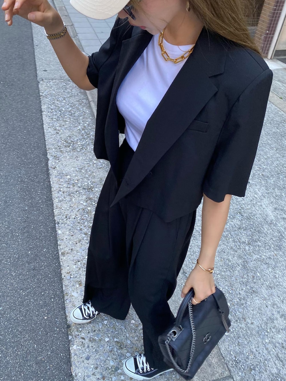 ホワイト系のTシャツ/カットソー、ブラック系のショルダーバッグ、ブラック系のスーツセットを着用したレディースの夏コーディネートの4枚目の写真