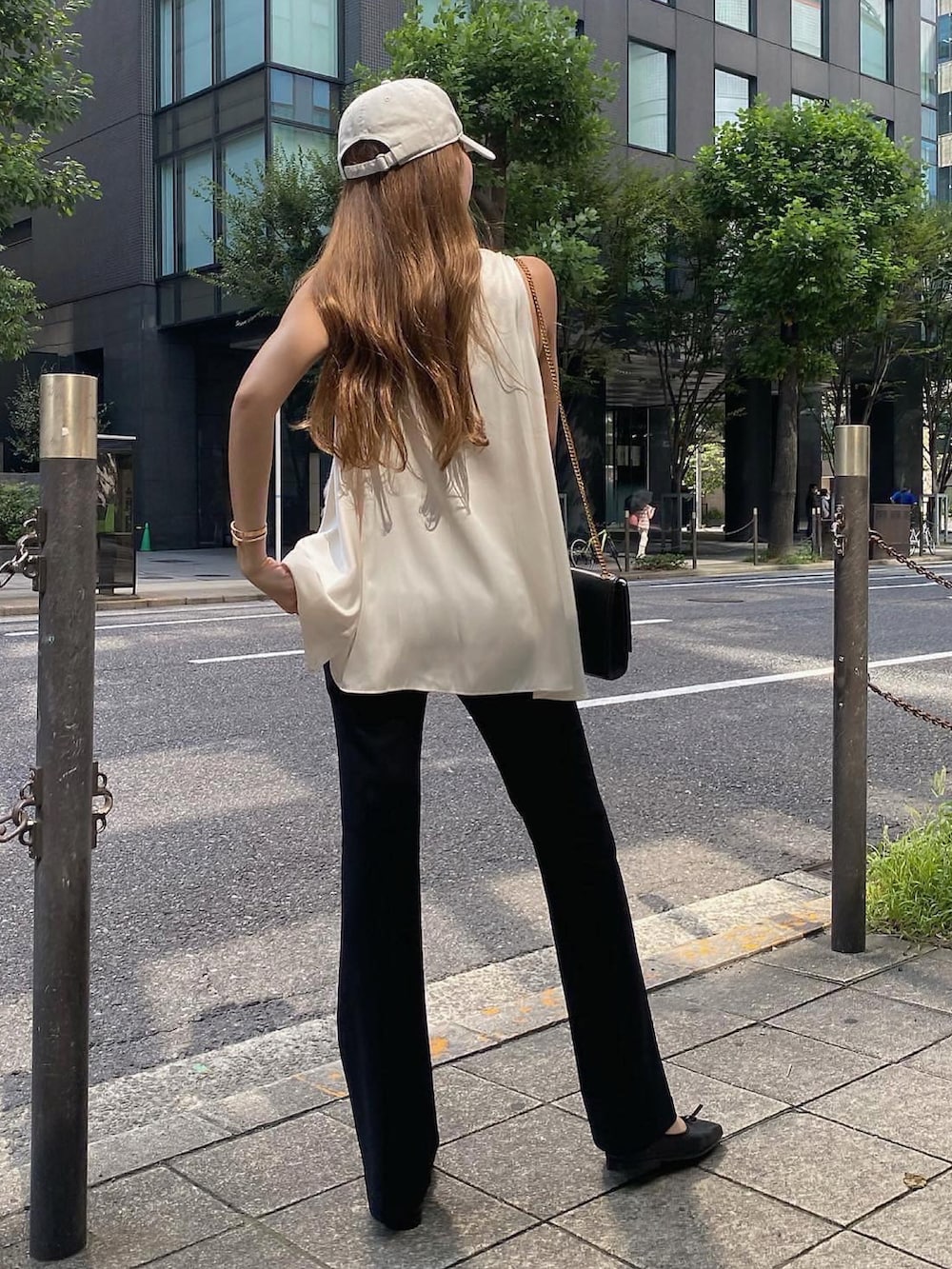 ホワイト系のトップス、ブラック系のスラックス、ブラック系のバレエシューズを着用したレディースの夏コーディネートの3枚目の写真