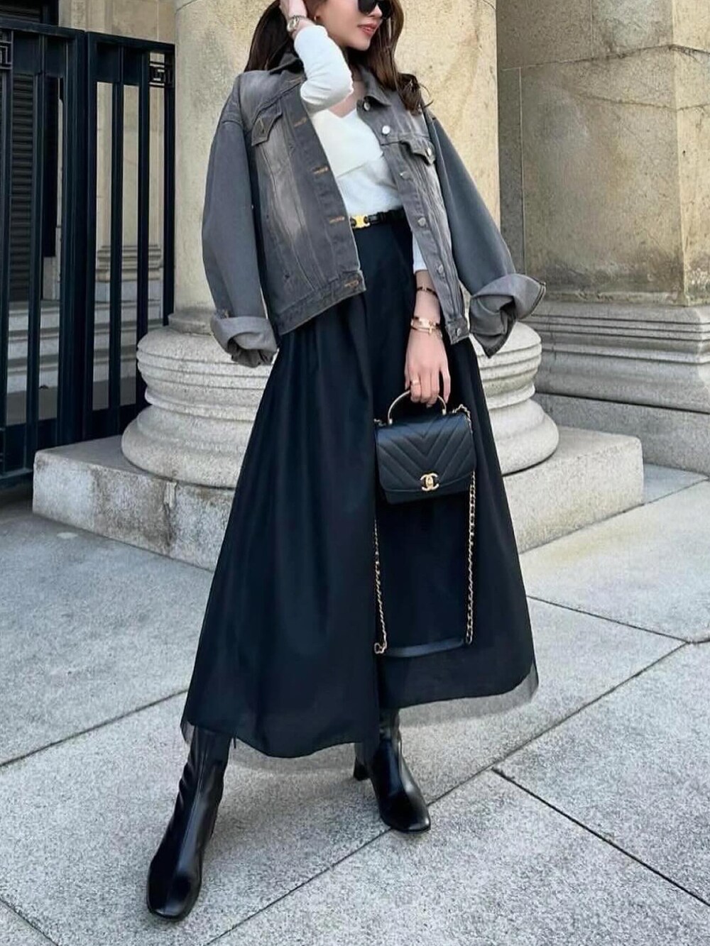 ブラック系のスカート、ブラック系のデニムジャケット、ブラック系のショルダーバッグを着用したレディースの春コーディネートの2枚目の写真