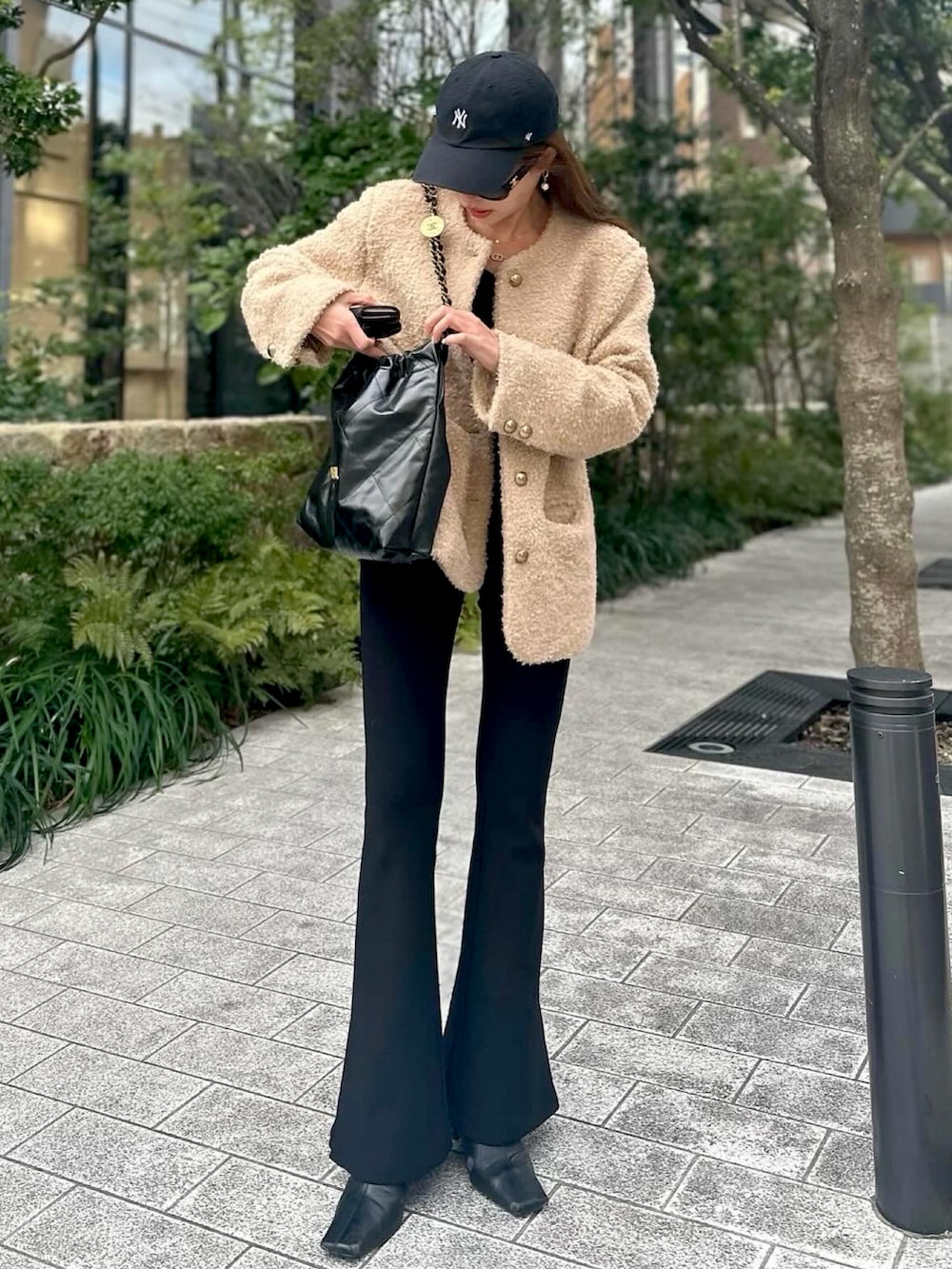 ブラック系のパンツ、ベージュ系のノーカラージャケット、ブラック系のショルダーバッグを着用したレディースの冬コーディネートの3枚目の写真