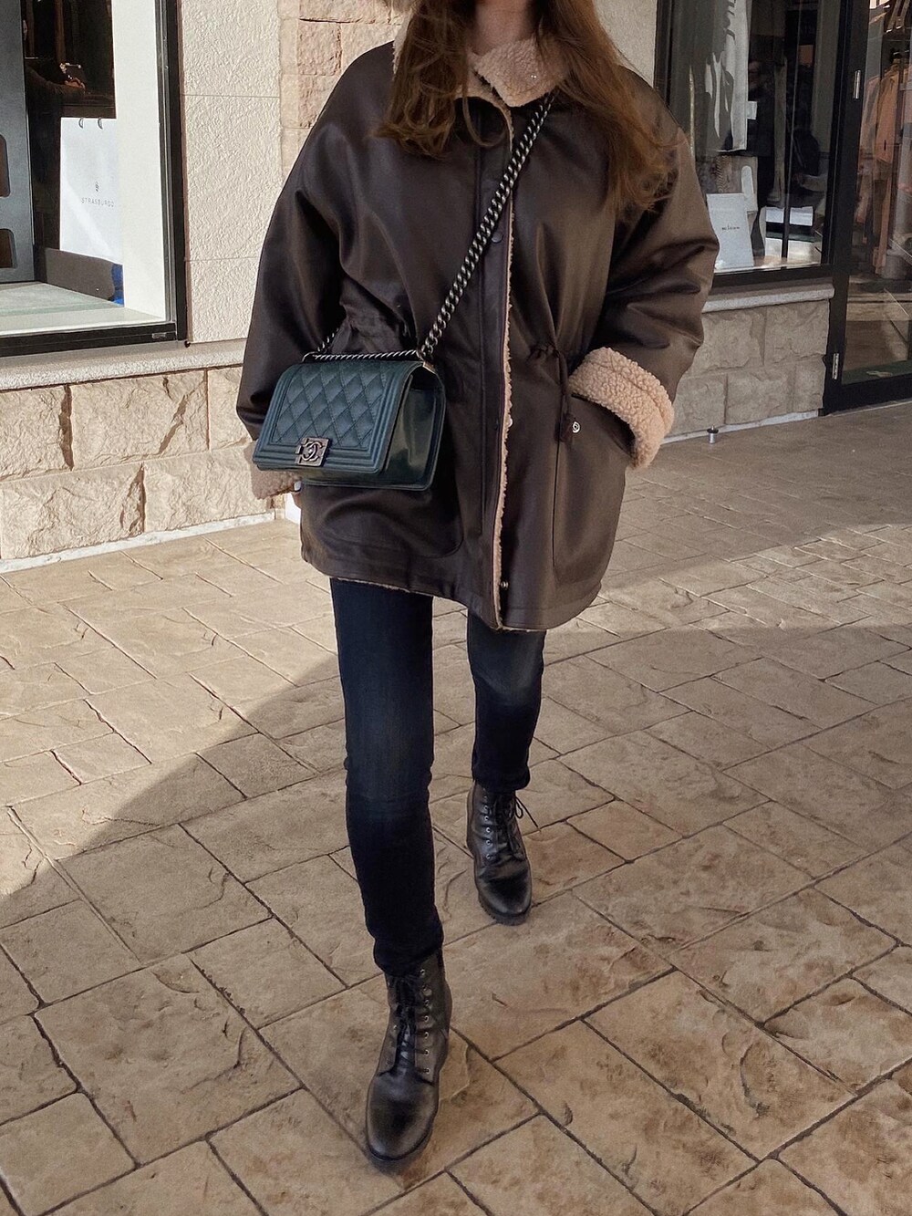 ブラウン系のジャケット/アウター、ブラック系のブーツ、グリーン系のショルダーバッグを着用したレディースの冬コーディネートの5枚目の写真