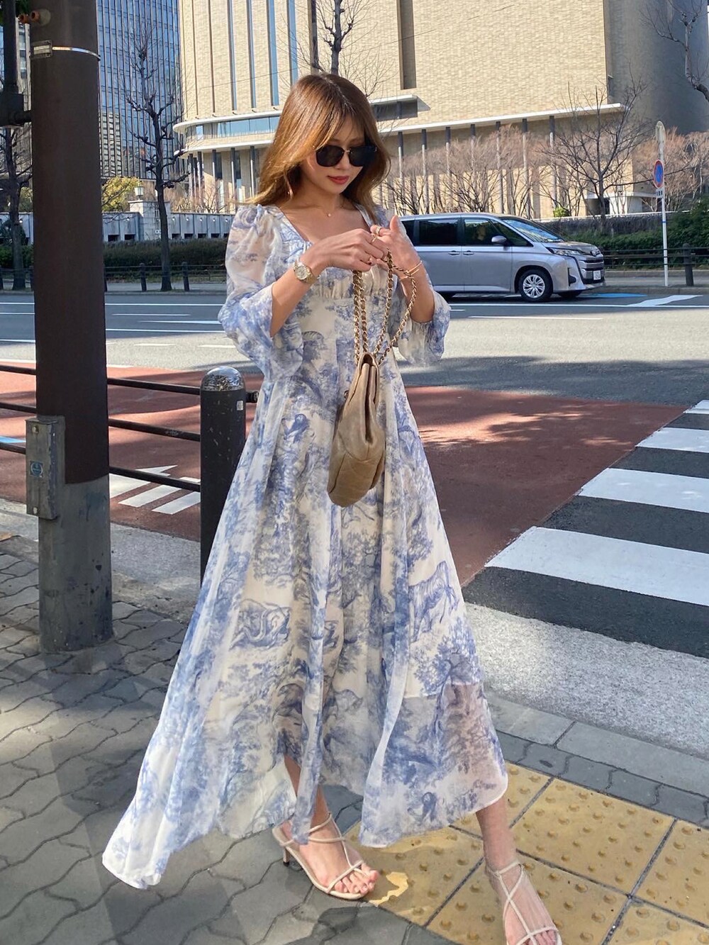 ブルー系のワンピース/ドレス、ゴールド系のショルダーバッグ、ホワイト系のサンダルを着用したレディースの春コーディネートの3枚目の写真