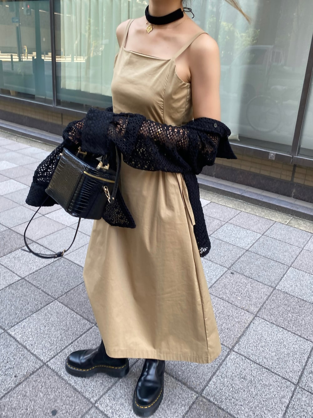 ブラック系のブーツ、ベージュ系のワンピース、ブラック系のシャツ/ブラウスを着用したレディースの夏コーディネートの2枚目の写真