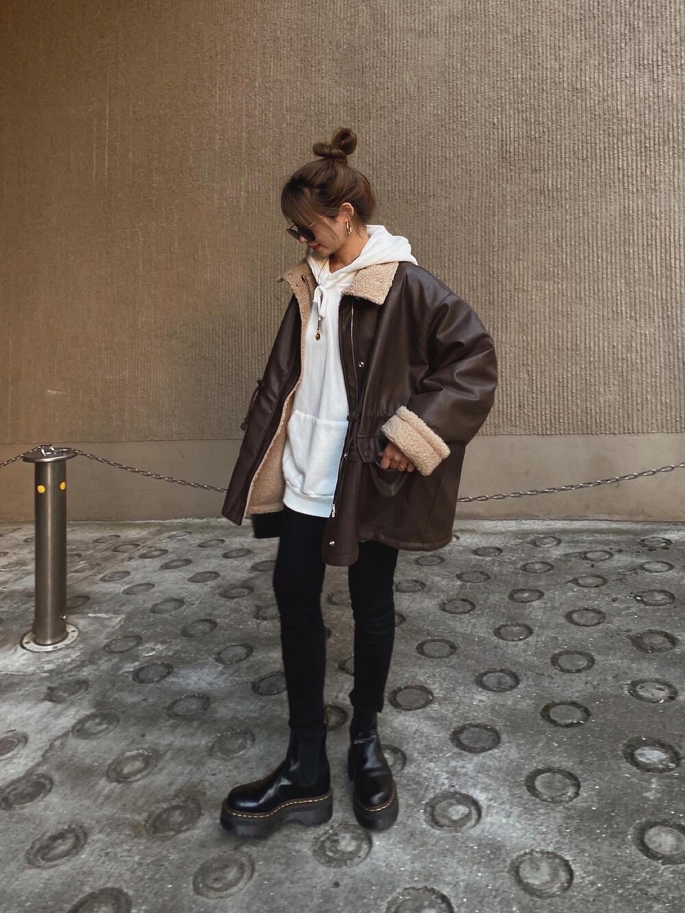 ブラウン系のジャケット/アウター、ホワイト系のパーカー、ブラック系のデニムパンツを着用したレディースの冬コーディネートの2枚目の写真