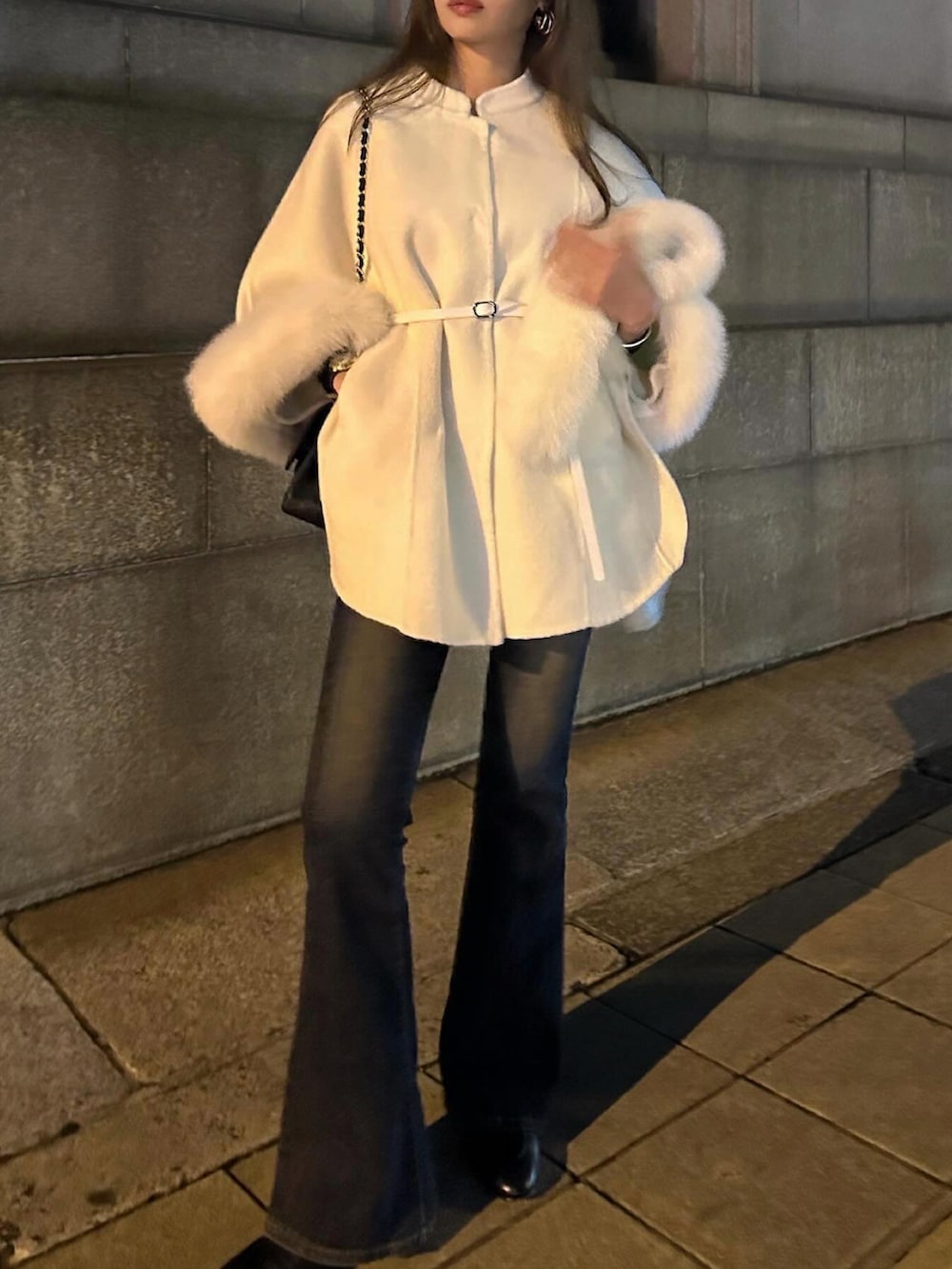 ブルー系のデニムパンツ、ホワイト系のジャケット/アウター、ブラック系のショルダーバッグを着用したレディースの冬コーディネートの4枚目の写真