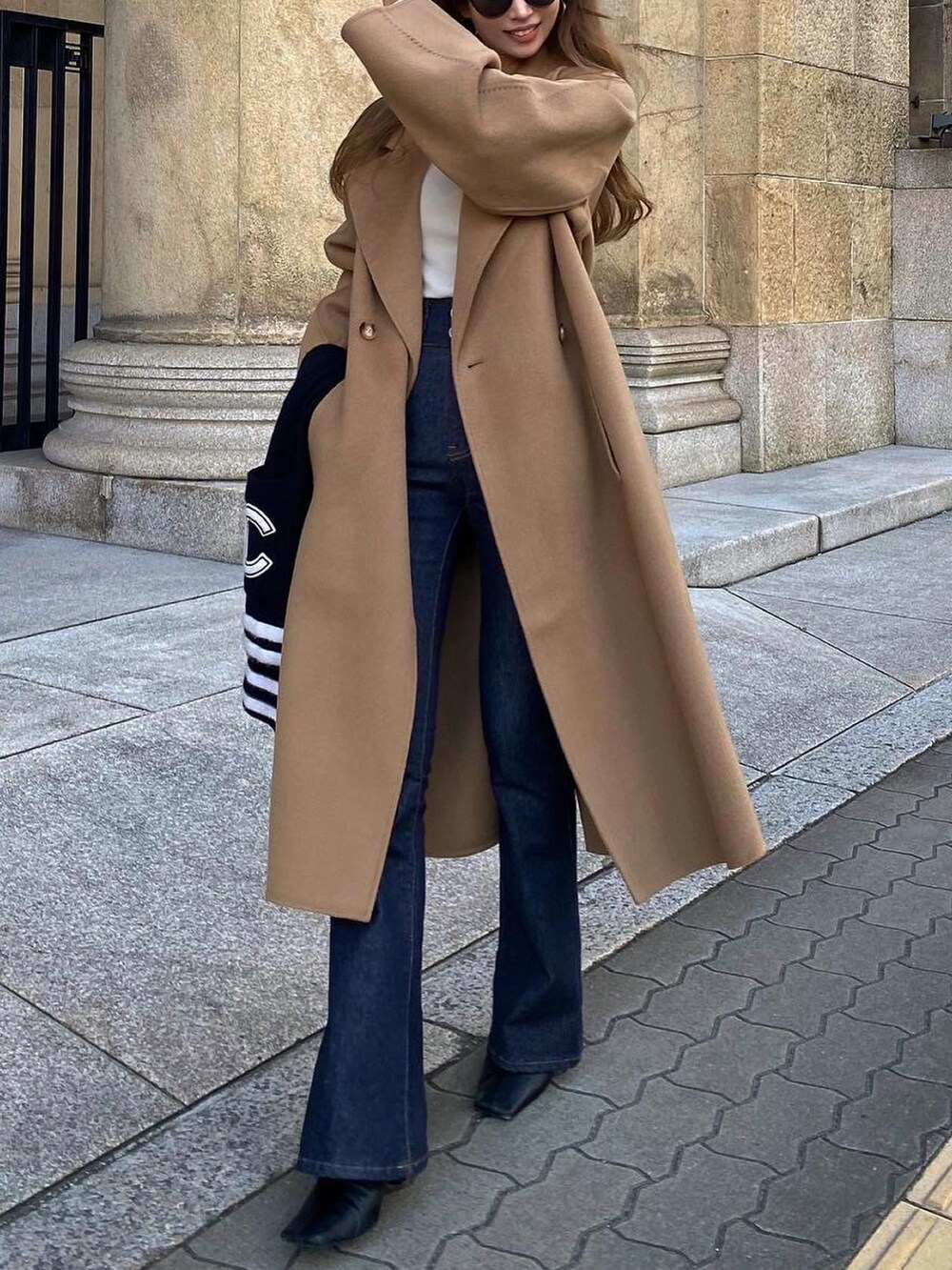 ブラウン系のジャケット/アウター、ブルー系のデニムパンツ、ブラック系のショルダーバッグを着用したレディースの秋コーディネートの4枚目の写真