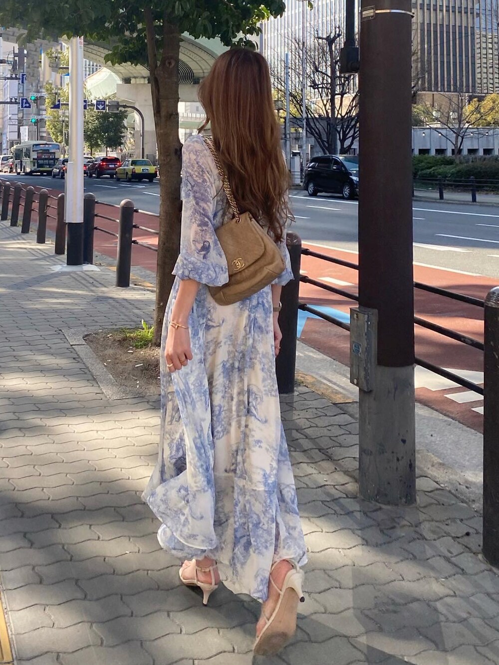 ブルー系のワンピース/ドレス、ゴールド系のショルダーバッグ、ホワイト系のサンダルを着用したレディースの春コーディネートの5枚目の写真