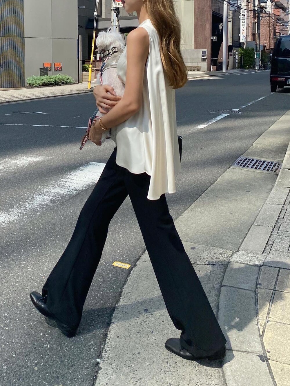 ホワイト系のトップス、ブラック系のスラックス、ブラック系のバレエシューズを着用したレディースの夏コーディネートの2枚目の写真