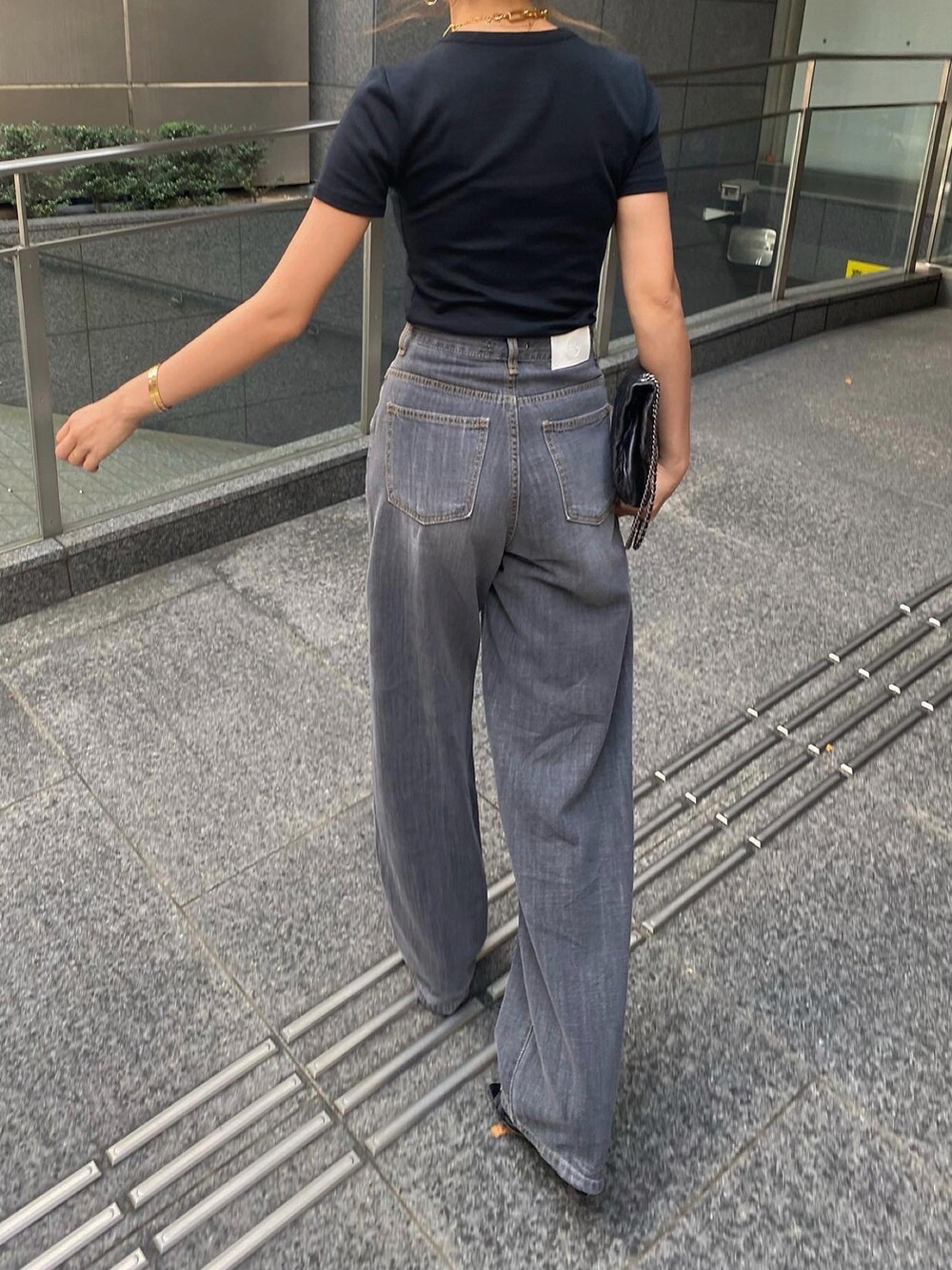 ブラック系のTシャツ/カットソー、ブラック系のデニムパンツ、ブラック系のショルダーバッグを着用したレディースの夏コーディネートの5枚目の写真