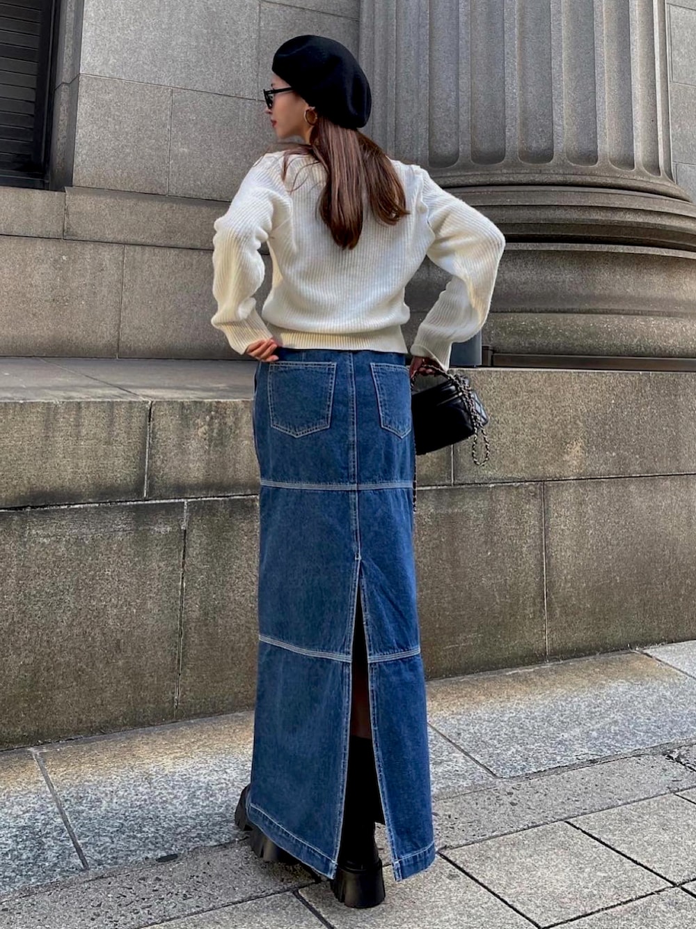 ブルー系のデニムスカート、ホワイト系のニット/セーターを着用したレディースの秋コーディネートの2枚目の写真