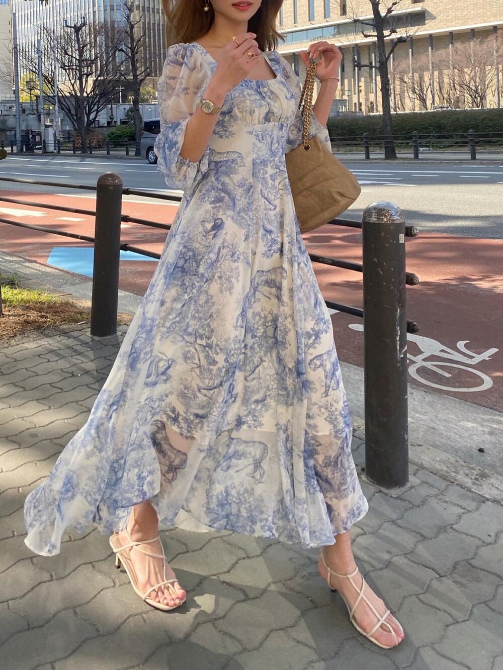 ブルー系のワンピース/ドレス、ゴールド系のショルダーバッグ、ホワイト系のサンダルを着用したレディースの春コーディネートの2枚目の写真