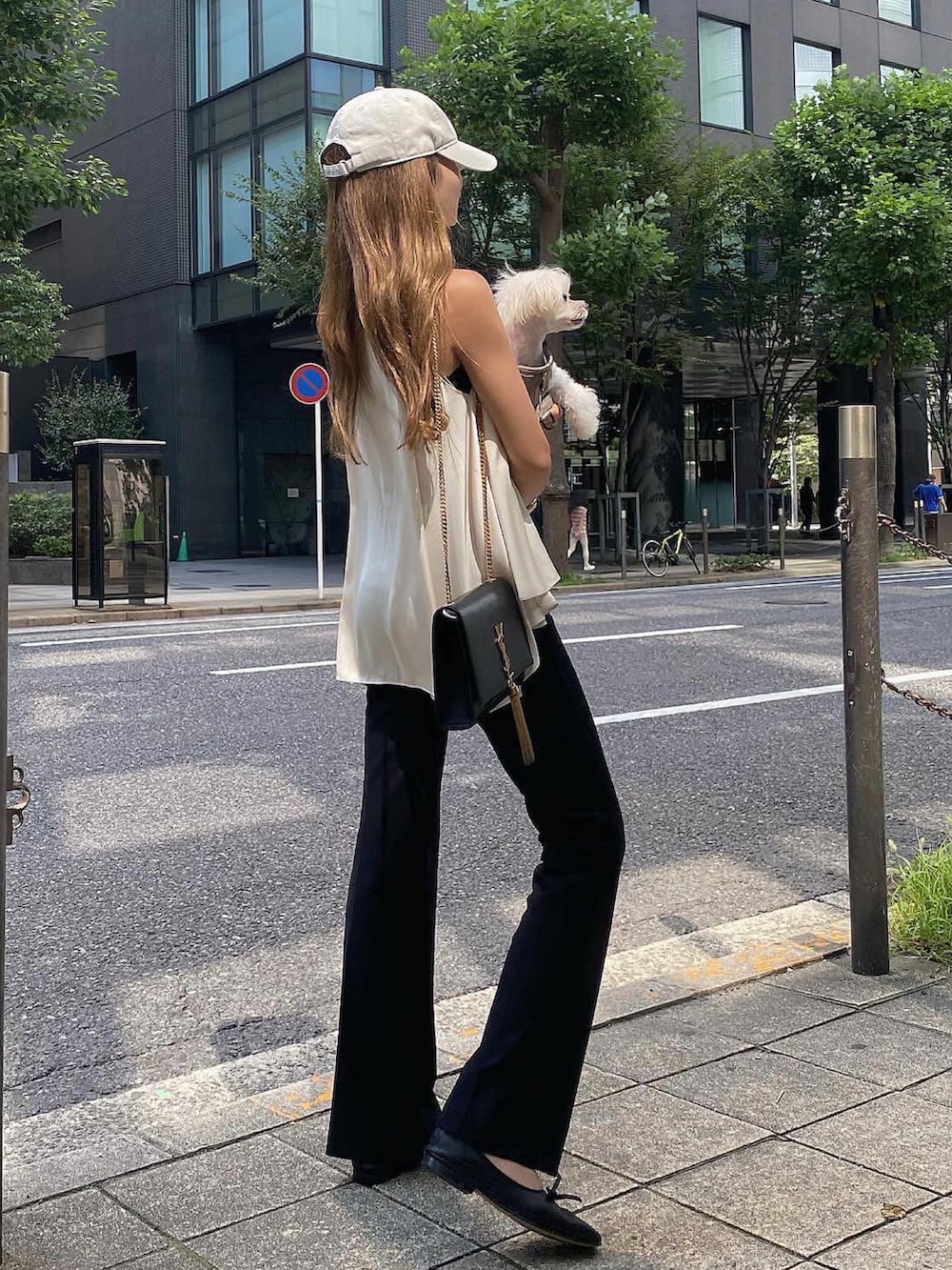 ホワイト系のトップス、ブラック系のスラックス、ブラック系のバレエシューズを着用したレディースの夏コーディネートの4枚目の写真