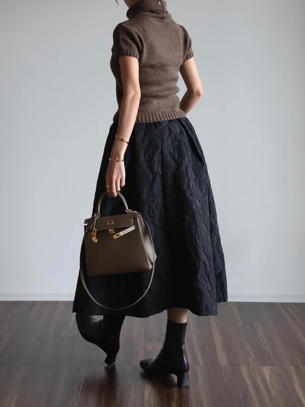ブラック系のスカート、その他のバッグ、ブラウン系のトップスを着用したレディースの春コーディネートの3枚目の写真