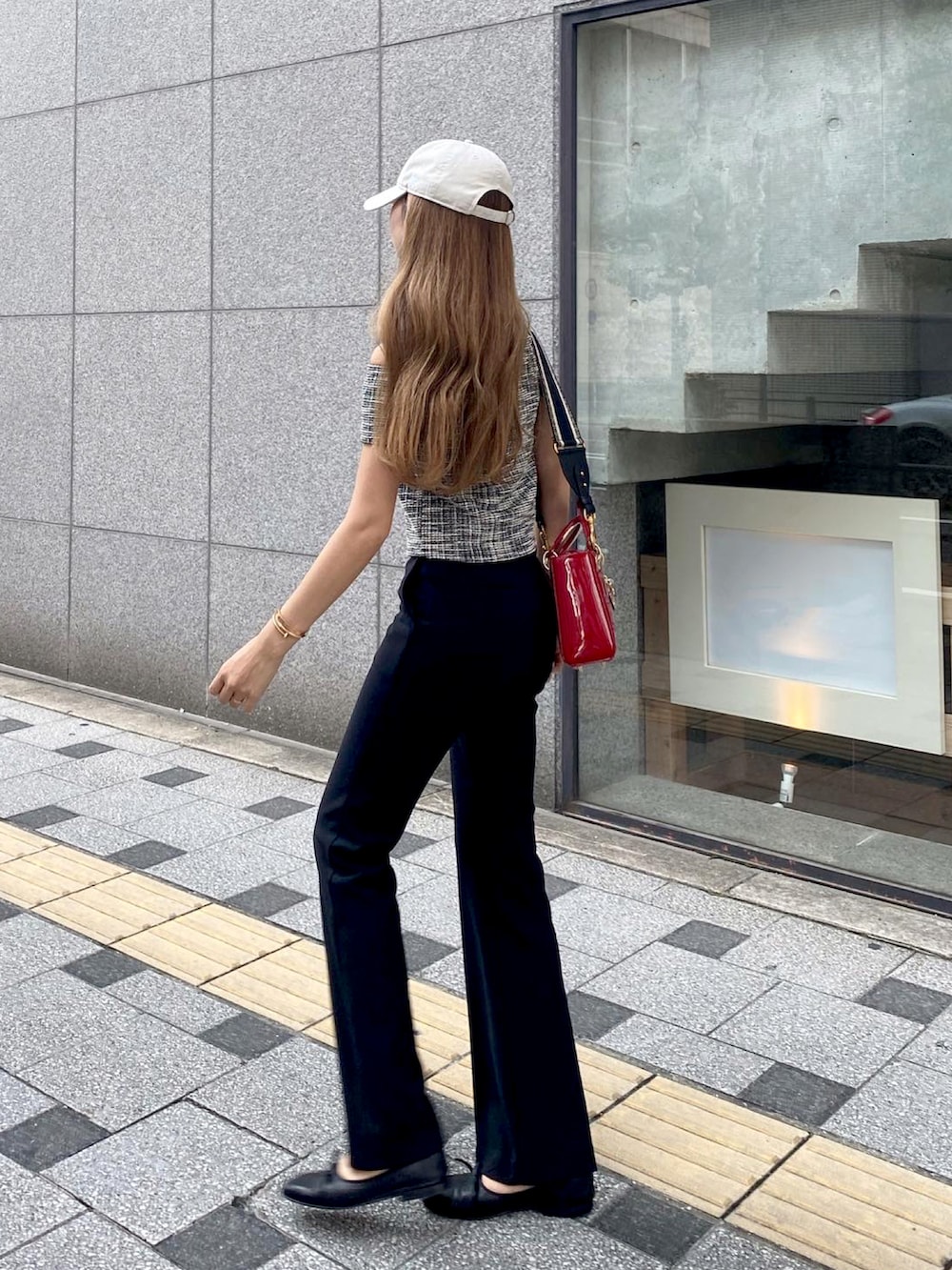 ブラック系のTシャツ/カットソー、レッド系のショルダーバッグ、ブラック系のスラックスを着用したレディースの夏コーディネートの5枚目の写真