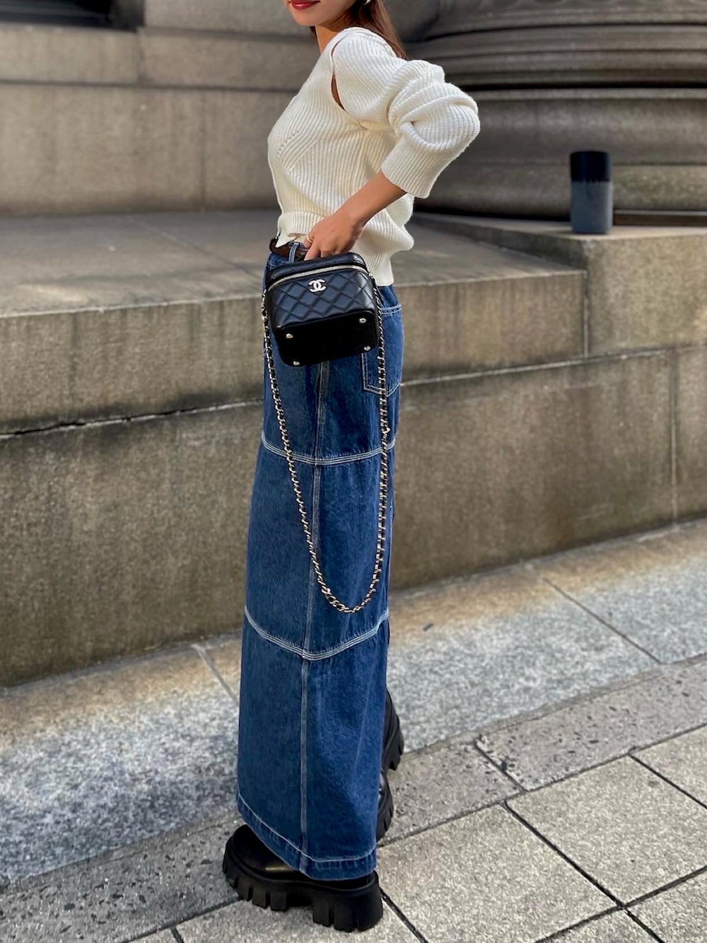 ブルー系のデニムスカート、ホワイト系のニット/セーターを着用したレディースの秋コーディネートの4枚目の写真