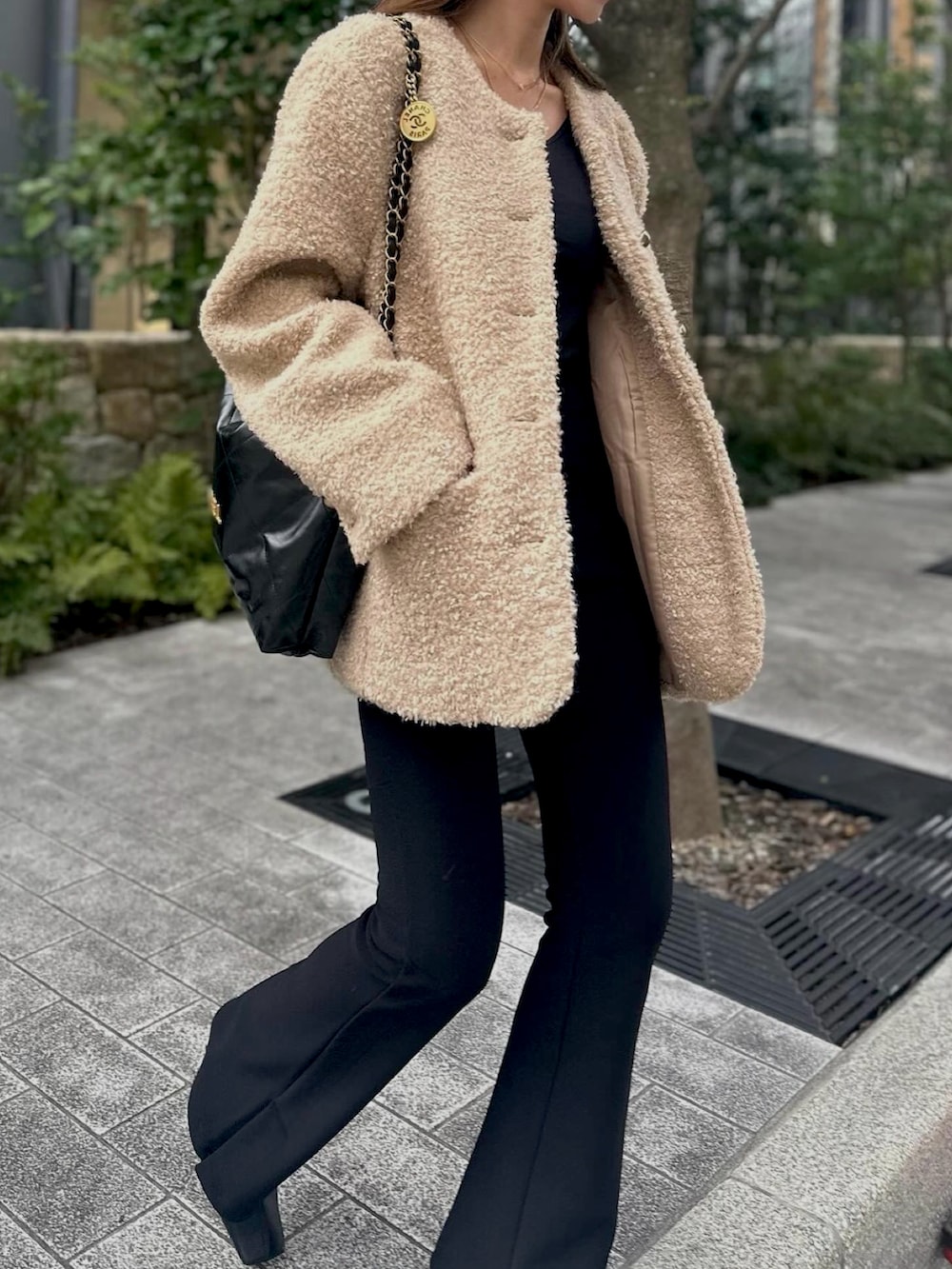 ブラック系のパンツ、ベージュ系のノーカラージャケット、ブラック系のショルダーバッグを着用したレディースの冬コーディネートの5枚目の写真