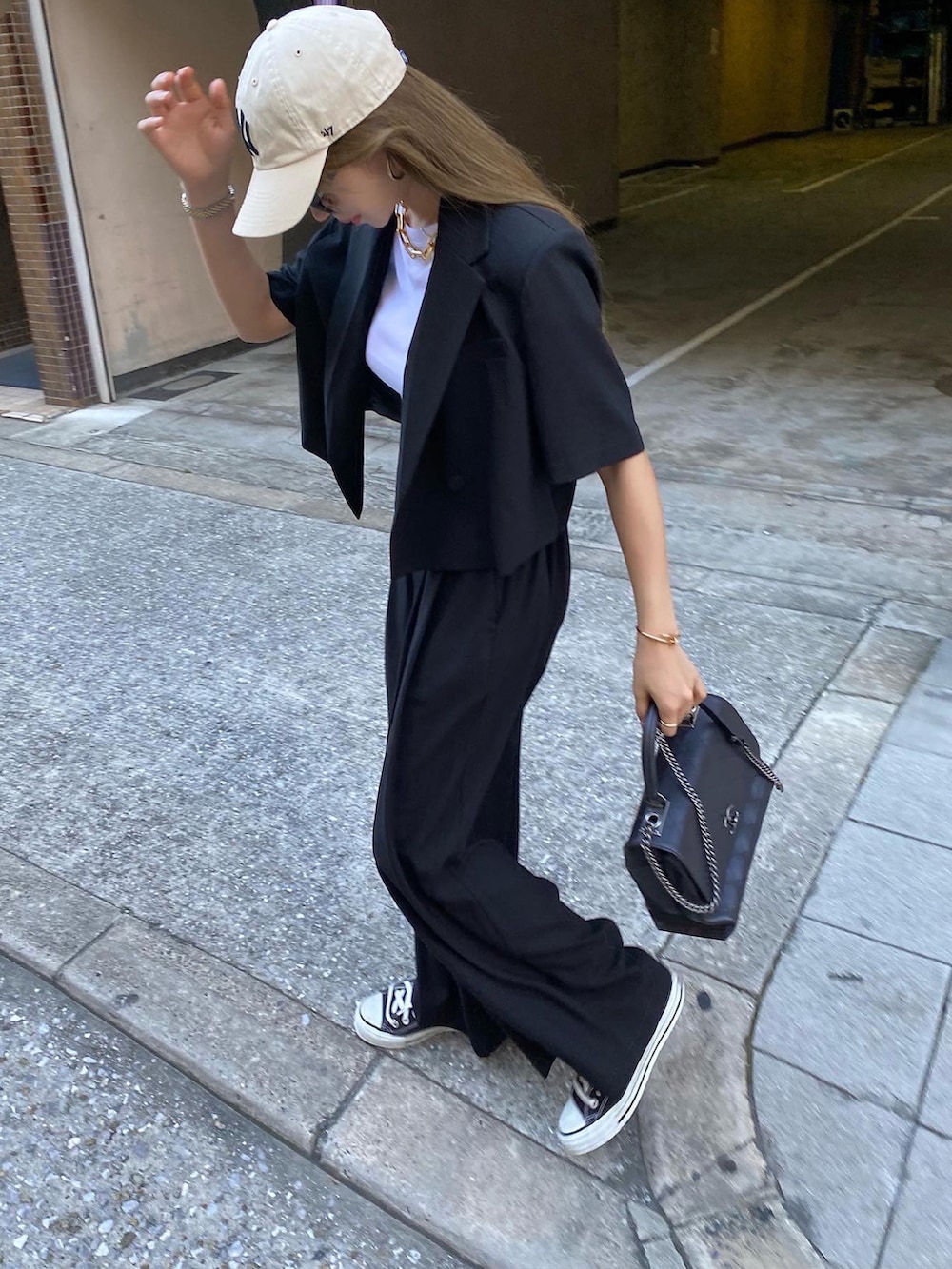 ホワイト系のTシャツ/カットソー、ブラック系のショルダーバッグ、ブラック系のスーツセットを着用したレディースの夏コーディネートの3枚目の写真