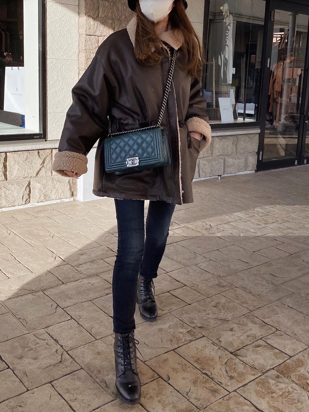 ブラウン系のジャケット/アウター、ブラック系のブーツ、グリーン系のショルダーバッグを着用したレディースの冬コーディネートの3枚目の写真