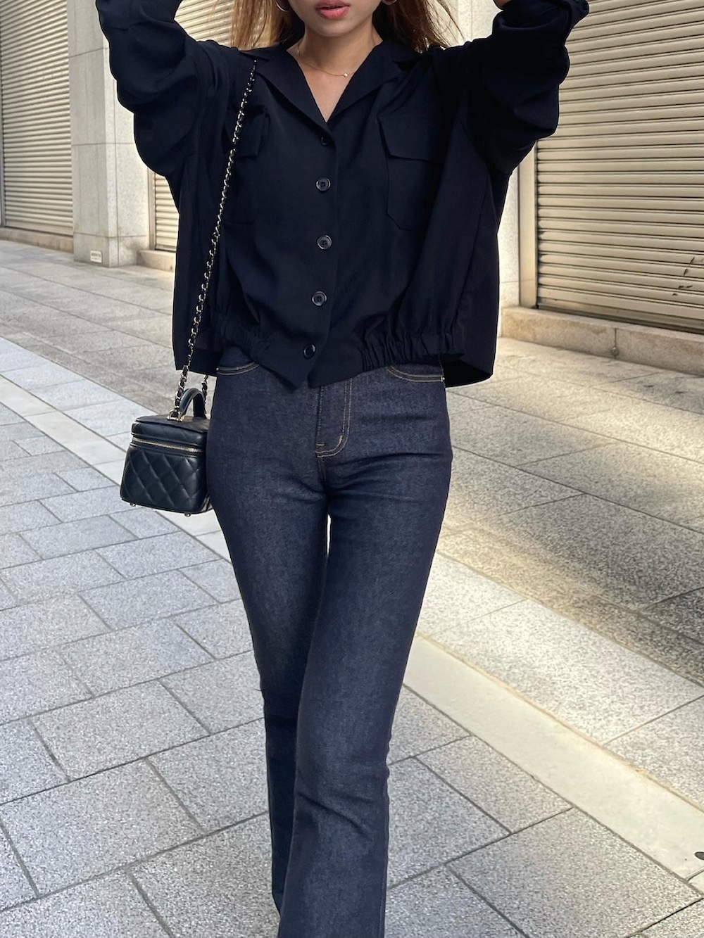 ブルー系のデニムパンツ、ブラック系のショルダーバッグ、ブラック系のシャツ/ブラウスを着用したレディースの秋コーディネートの3枚目の写真