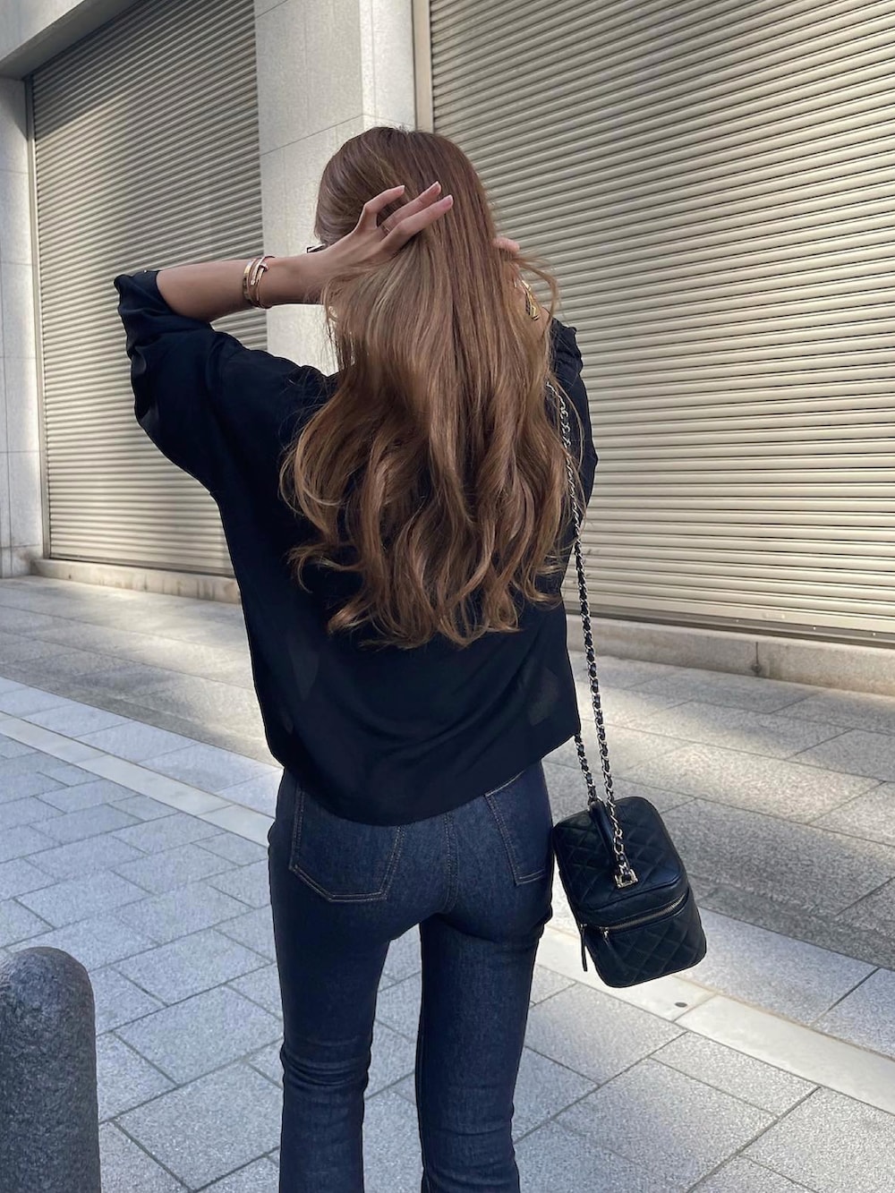 ブルー系のデニムパンツ、ブラック系のショルダーバッグ、ブラック系のシャツ/ブラウスを着用したレディースの秋コーディネートの4枚目の写真