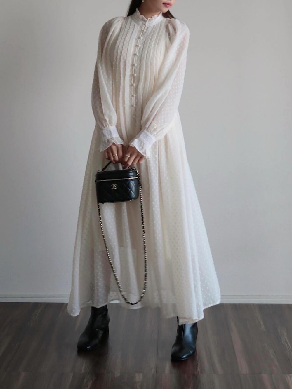 ホワイト系のワンピース、ベージュ系のキャップを着用したレディースの春コーディネートの2枚目の写真