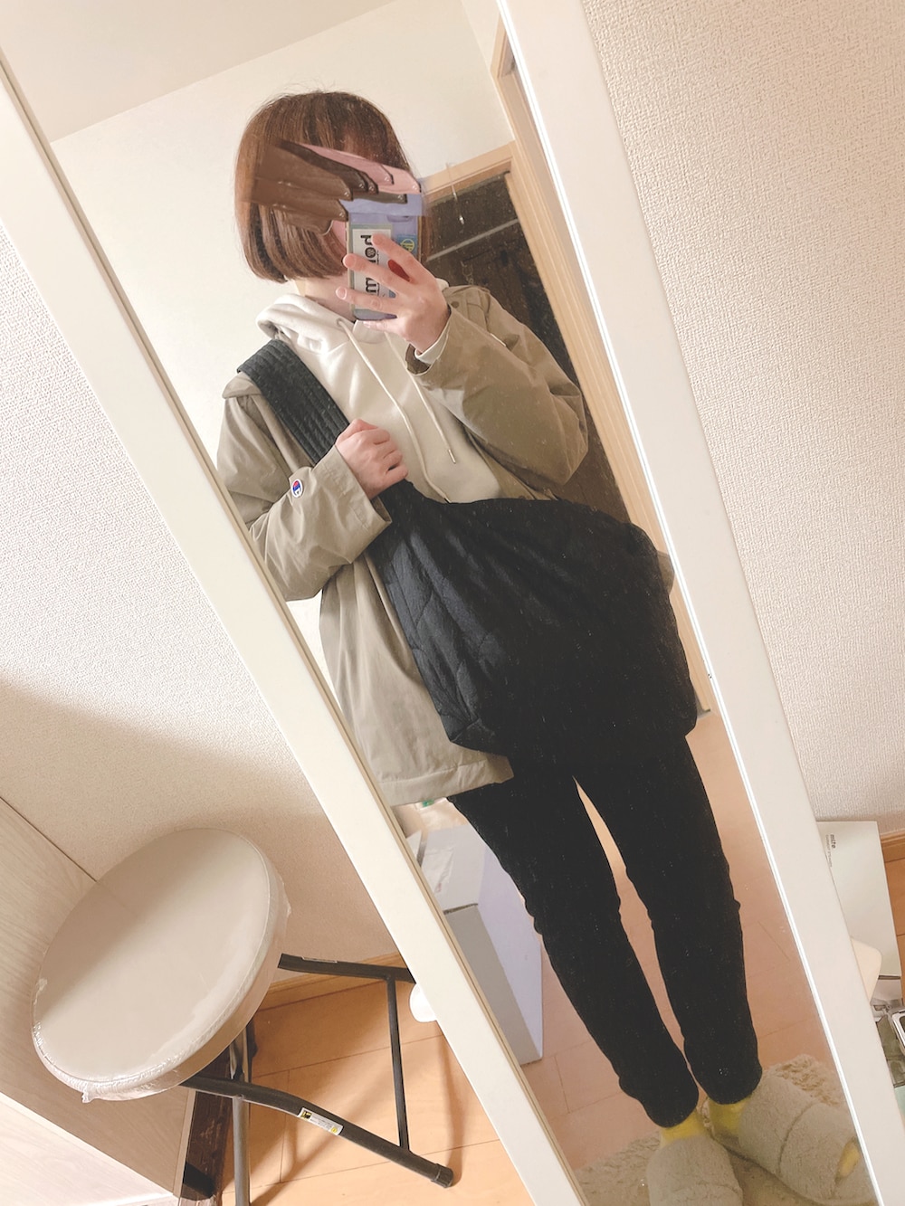 ホワイト系のパーカー、ブラック系のパンツ、ブラック系のショルダーバッグを着用したレディースの春コーディネートの2枚目の写真