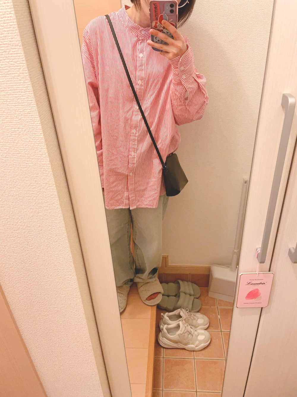 ピンク系のシャツ/ブラウス、ブルー系のデニムパンツ、ブラック系のショルダーバッグを着用したレディースの春コーディネートの2枚目の写真