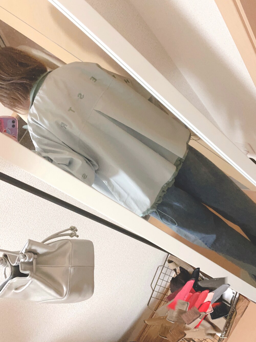 ホワイト系のナイロンジャケット、ベージュ系のTシャツ/カットソー、ブルー系のデニムパンツを着用したレディースの春コーディネートの2枚目の写真