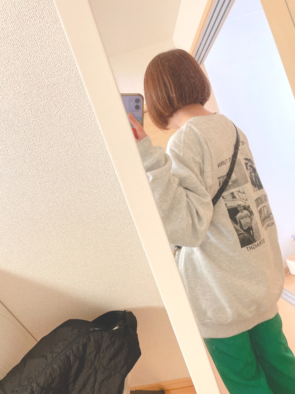 グレー系のスウェット、ホワイト系のTシャツ/カットソー、ブラック系のショルダーバッグを着用したレディースの春コーディネートの2枚目の写真