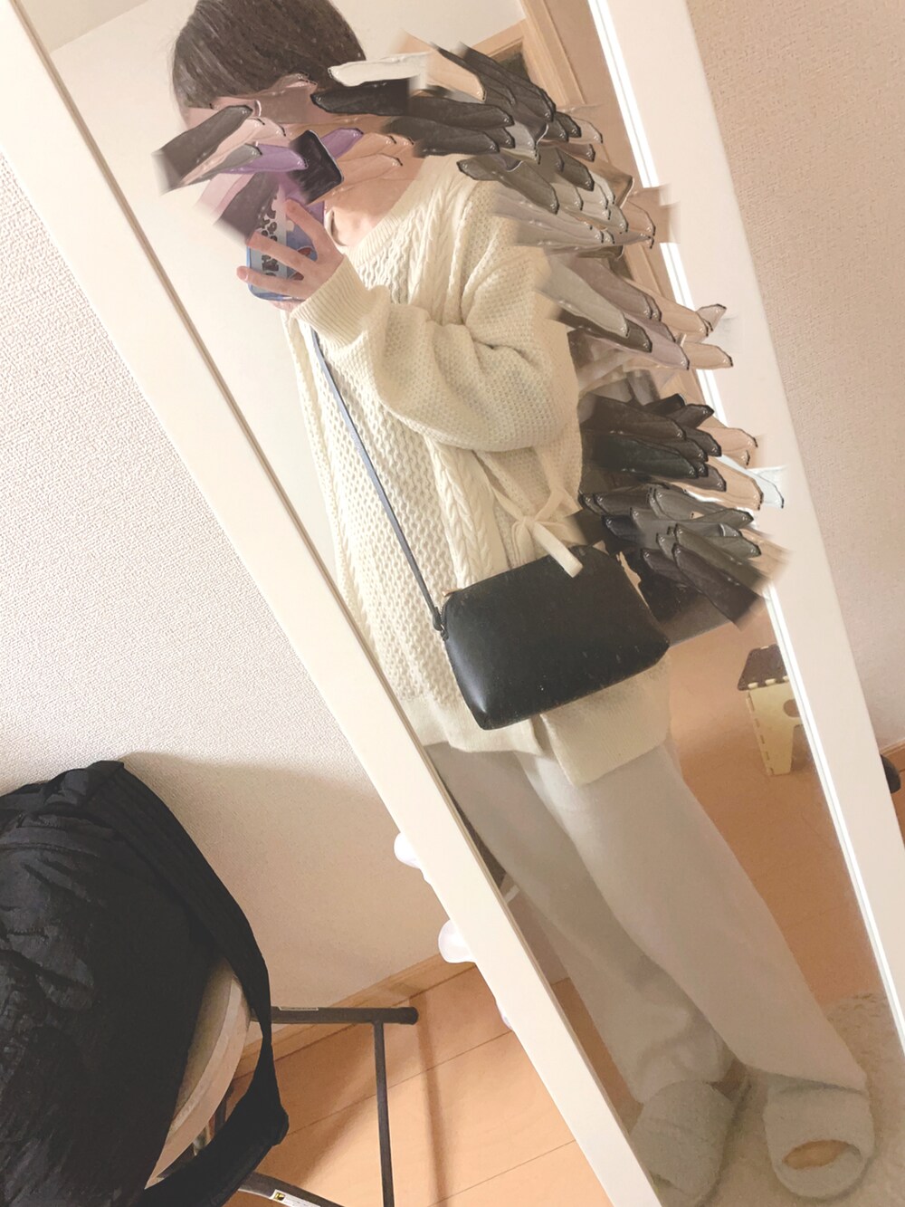 ブラック系のダウンジャケット/コート、ブラック系のショルダーバッグ、ホワイト系のニット/セーターを着用したレディースの冬コーディネートの2枚目の写真