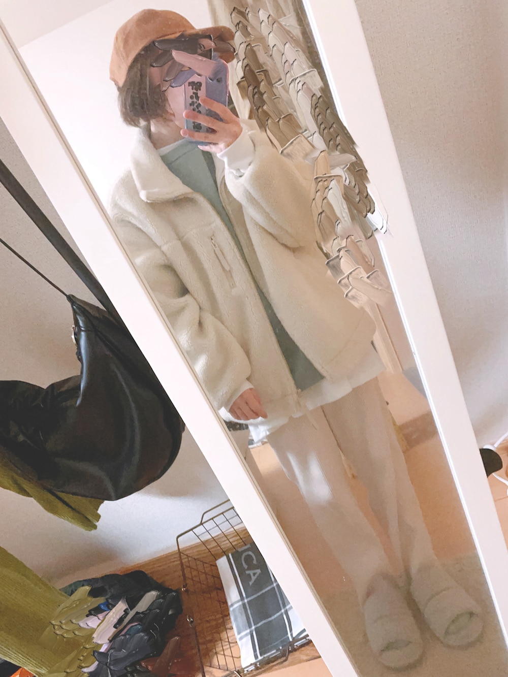 ホワイト系のTシャツ/カットソー、ブラウン系のトートバッグ、ホワイト系のブルゾンを着用したレディースの冬コーディネートの2枚目の写真